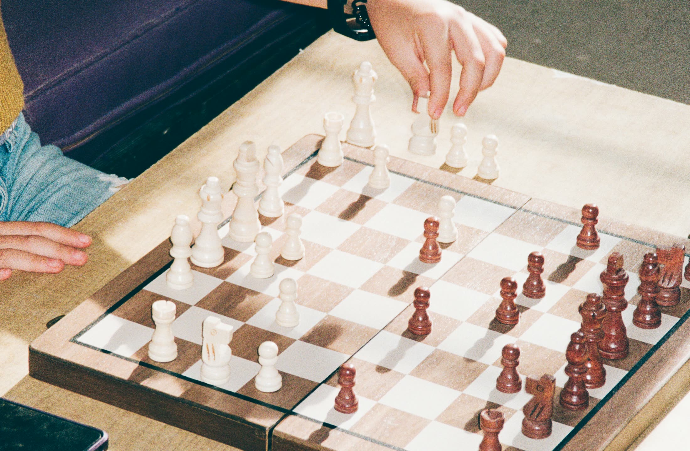 A close game of chess mid-move — strategy and patience.